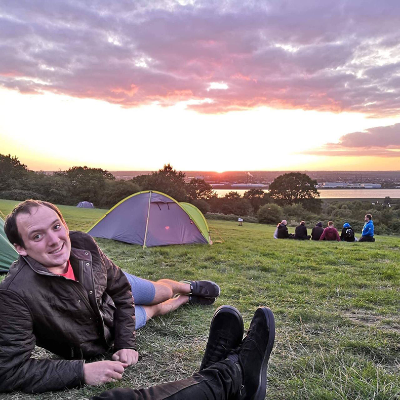 Image of Rob sat in front of a tent at Essex Chase, Gilwell Park